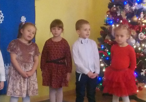 Dziewczynki i chłopaki śpiewają piosenkę świąteczną.