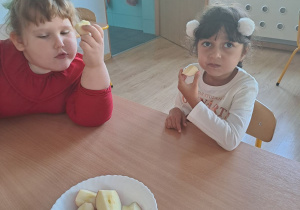 Dzieci jedzą zdrowe jabłka.