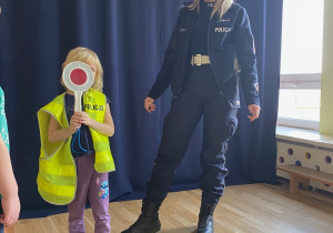 Iga schowana za policyjnym lizakiem.